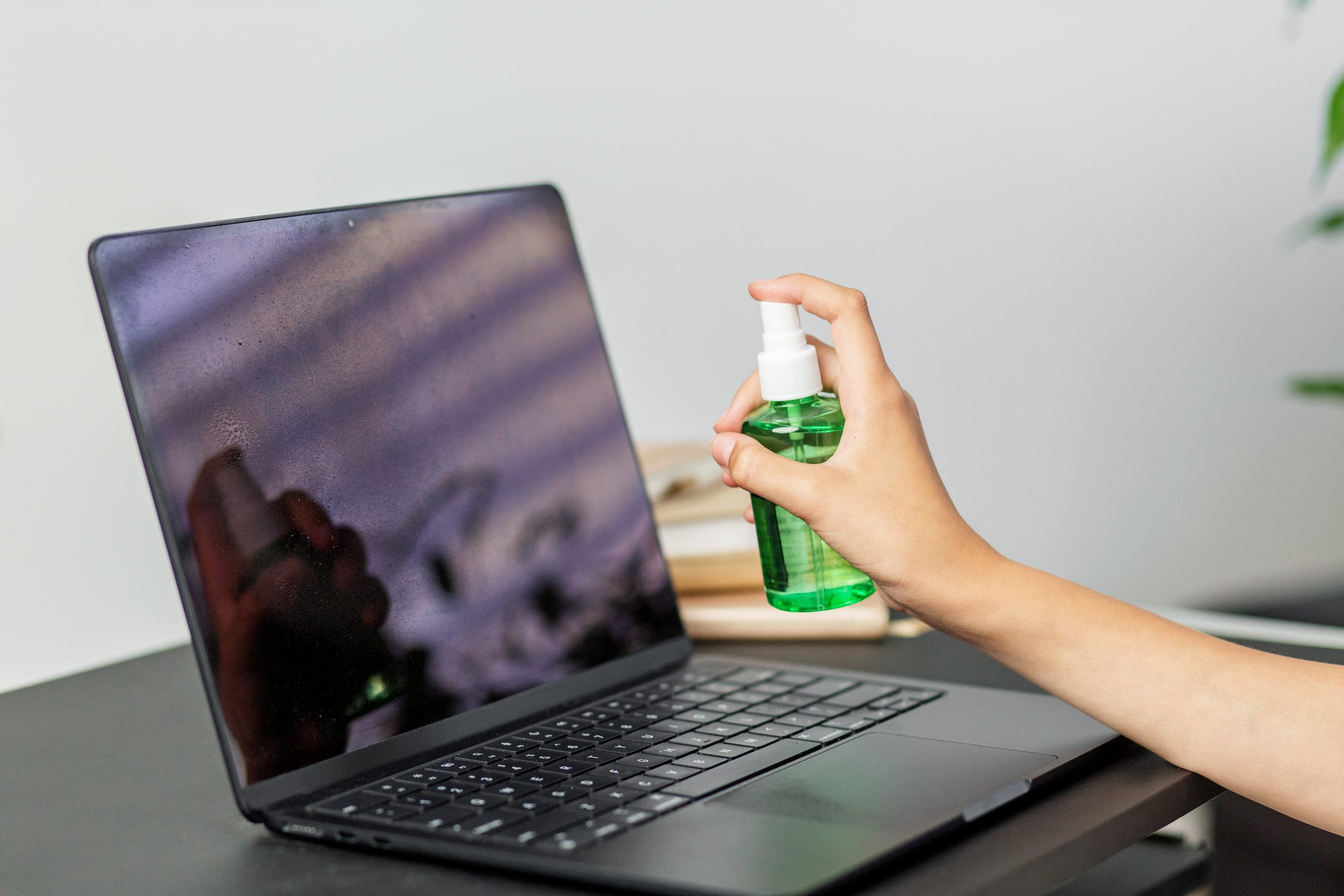 spraying laptop screen with green cleaning solutio 2025 07 13 05 00 08 utc scaled - Flexidesk
