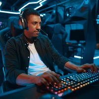 A man plays games in a computer club. A man plays games in a computer club.