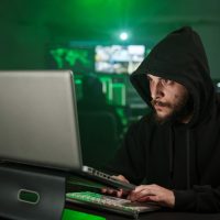 Hacker man typing on laptop, hacking computer system with virus Hacker man typing on laptop, hacking computer system with virus