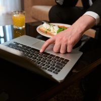 Man eating and touching laptop in the motel Man eating and touching laptop in the motel